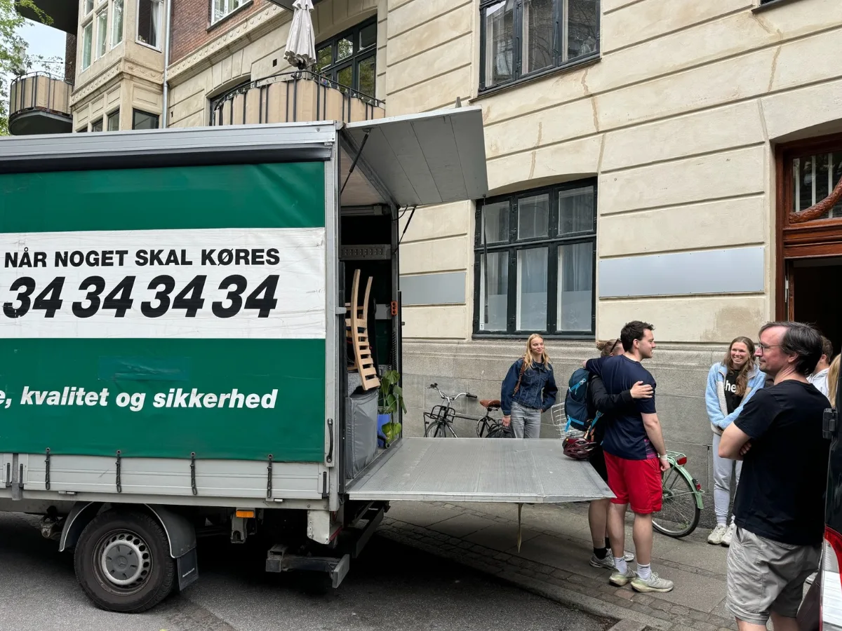 Moving van loads furniture at the entrance; customer's own moving team carries belongings up the stairs — we provide transport and loading.