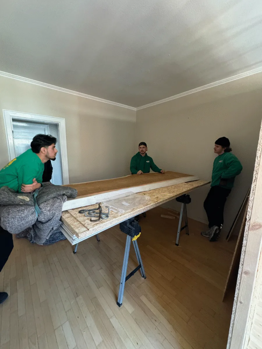 Et team arbejder på at flytte en massiv bordplade ned ad trapper i København for at sikre en sikker og effektiv transport.