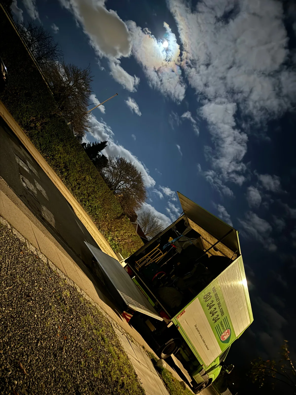 En lastbil er klar til at flytte om aftenen i København med månen i baggrunden. Professionelle flyttetjenester ved hjælp af nogens brand.