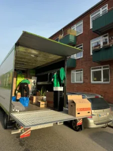 En flyttemand pakker en flyttevogn i København med flyttekasser og møbler.