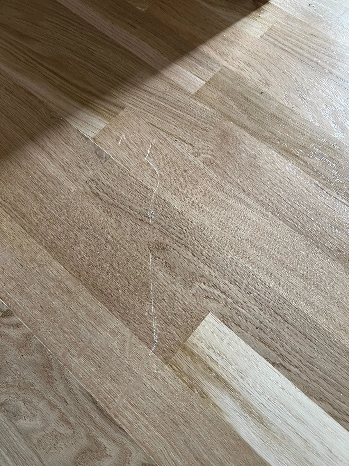 Skader på trægulv som følge af flytning i København. Visuel illustration af ansvar hos flyttefirmaer.