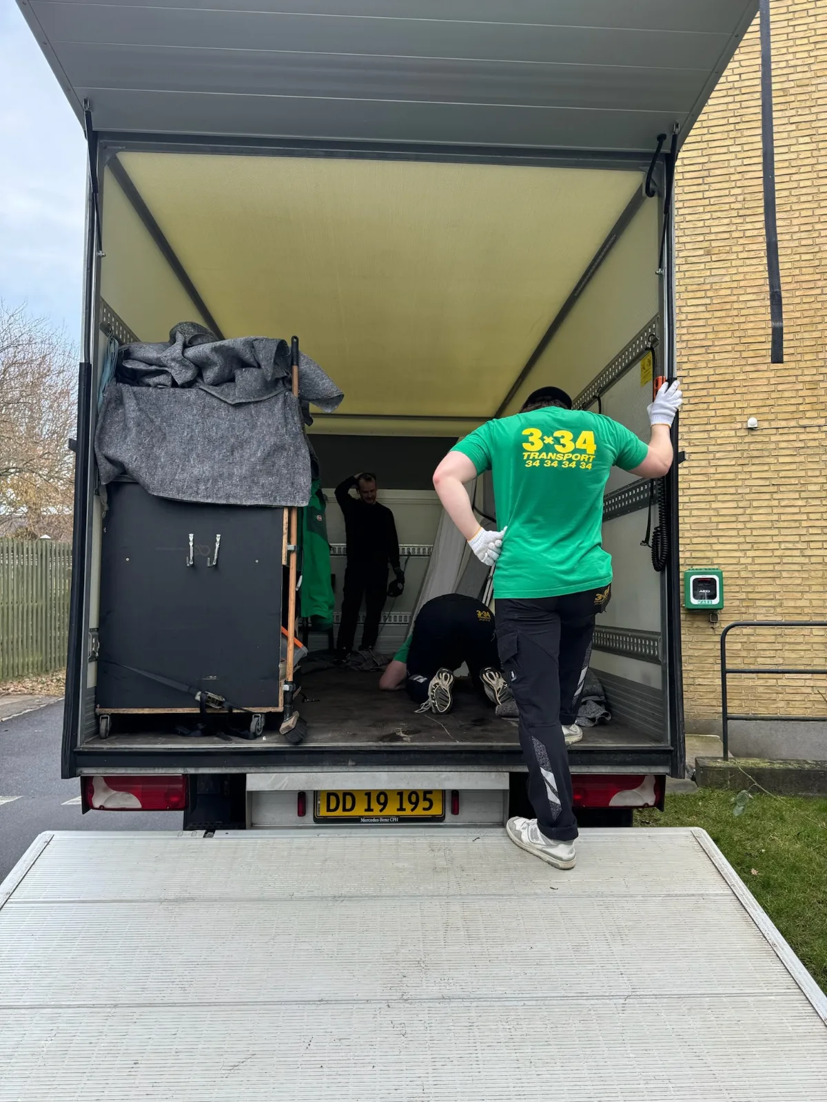 Billede af flyttefolk i en lastbil under en flytning i København, der håndterer møbler.