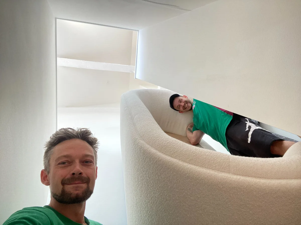 En hvid sofa, der forsigtigt flyttes på tæpper i København