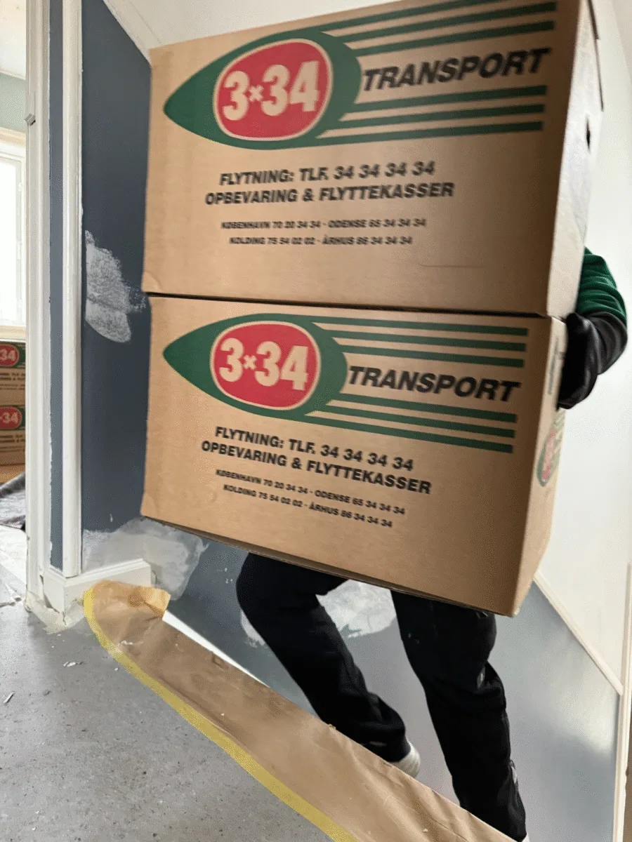 To kasser fra 3*34 transport blive båret i en bolig i København.